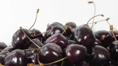 Kiraz. Olgun kiraz beyaz arka plan üzerinde döner. Dönen siyah Olgun tatlı kiraz. Döndürme 4k Uhd video. Döngü sorunsuz imkanı. Closeup Makro.