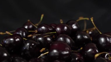 Kiraz. Olgun kiraz siyah arka plan üzerinde döner. Dönen siyah Olgun tatlı kiraz. Döndürme 4k Uhd video. Döngü sorunsuz imkanı. Closeup Makro.