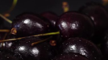 Kiraz. Olgun kiraz siyah arka plan üzerinde döner. Dönen siyah Olgun tatlı kiraz. Döndürme 4k Uhd video. Döngü sorunsuz imkanı. Closeup Makro.
