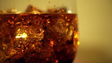 Cola cam buz küpleri ve döner kabarcıklar ile. Gıda arka plan. Soda yakın çekim.