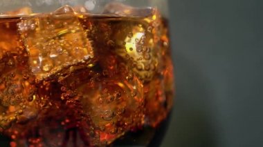 Cola cam buz küpleri ve döner kabarcıklar ile. Gıda arka plan. Soda yakın çekim.