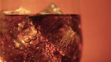 Cola cam buz küpleri ve döner kabarcıklar ile. Gıda arka plan. Soda yakın çekim.