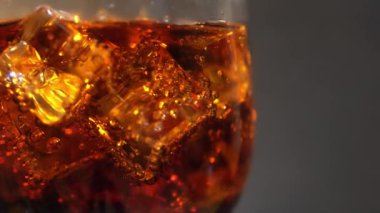 Cola cam buz küpleri ve döner kabarcıklar ile. Gıda arka plan. Soda yakın çekim.
