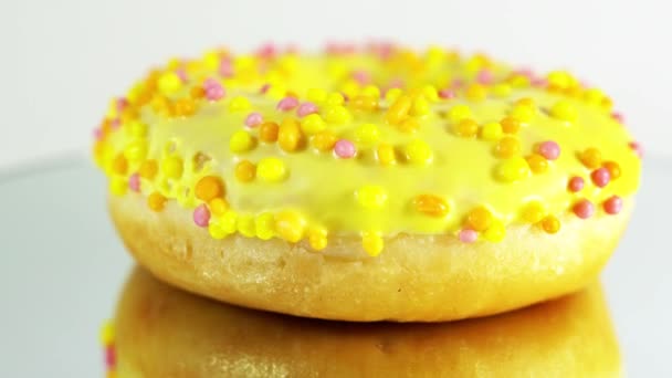 Roterende donuts met verschillende vullingen op de spiegel tafel. Heerlijke zoete donut draaiend op een bord. Heldere en kleurrijke donut close-up macro schot spinnen op een witte achtergrond. Naadloze lus. — Stockvideo