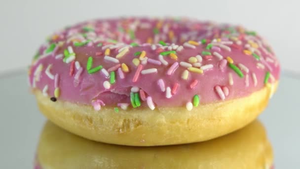 Donuts rotativos com diferentes recheios na mesa de espelho. Delicioso donut doce girando em um prato. Donut brilhante e colorido close-up macro tiro girando em um fundo branco. loop sem costura . — Vídeo de Stock
