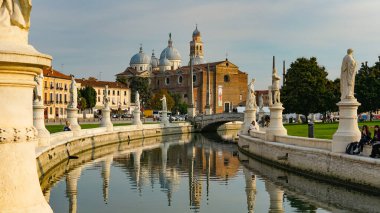 PADUA, İtalya - 2017 Piazza Prato della Valle, Santa Giustina Manastırı. Prato della Valle eliptik karesi merkezde yeşil bir ada, küçük bir kanal ile çevrili ve iki heykel halkası ile çevrili.