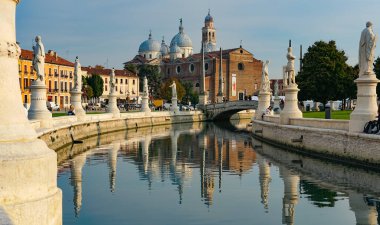 PADUA, İtalya - 2017 Piazza Prato della Valle, Santa Giustina Manastırı. Prato della Valle eliptik karesi merkezde yeşil bir ada, küçük bir kanal ile çevrili ve iki heykel halkası ile çevrili.