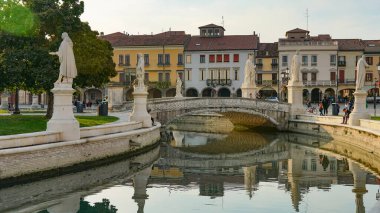PADUA, İtalya - 2017 Piazza Prato della Valle, Santa Giustina Manastırı. Prato della Valle eliptik karesi merkezde yeşil bir ada, küçük bir kanal ile çevrili ve iki heykel halkası ile çevrili.