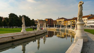 PADUA, İtalya - 2017 Piazza Prato della Valle, Santa Giustina Manastırı. Prato della Valle eliptik karesi merkezde yeşil bir ada, küçük bir kanal ile çevrili ve iki heykel halkası ile çevrili.