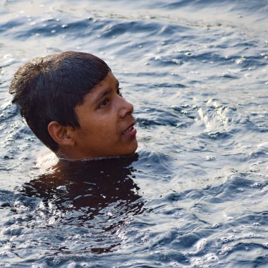 Delhi, Hindistan - 31 Aralık 2019: Delhi 'de sabah vakti kutsal Yamuna nehrinde banyo yapan adam, Yamuna nehrinde kutsal dalış yapan insanlar