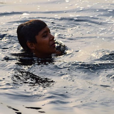 Delhi, Hindistan - 31 Aralık 2019: Delhi 'de sabah vakti kutsal Yamuna nehrinde banyo yapan adam, Yamuna nehrinde kutsal dalış yapan insanlar