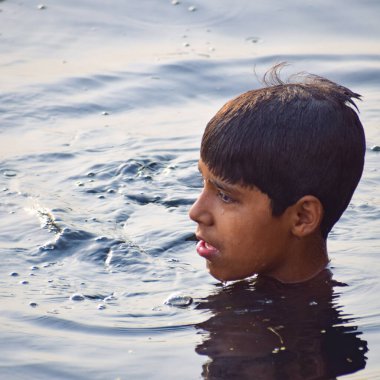 Delhi, Hindistan - 31 Aralık 2019: Delhi 'de sabah vakti kutsal Yamuna nehrinde banyo yapan adam, Yamuna nehrinde kutsal dalış yapan insanlar