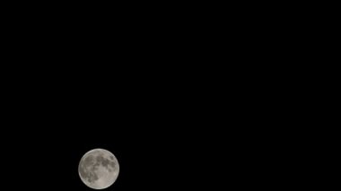 Moon Timelapse, Stock zamanaşımı: Dolunay karanlık gökyüzünde yükseliyor, gece vakti. Dolunay zamanı, gece karanlığında karanlık gökyüzünde ay ışığıyla birlikte kaybolur. Yüksek kaliteli beleş video kaydı veya zaman ayarlı