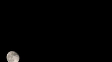 Moon Timelapse, Stock zamanaşımı: Dolunay karanlık gökyüzünde yükseliyor, gece vakti. Dolunay zamanı, gece karanlığında karanlık gökyüzünde ay ışığıyla birlikte kaybolur. Yüksek kaliteli beleş video kaydı veya zaman ayarlı