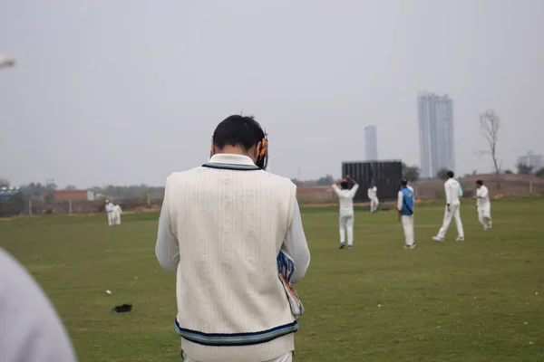 Full length of cricketer playing on field during sunny day, Cricketer on the field in action, Players playing cricket match at field during the day time