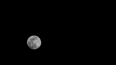 Moon Timelapse, Stock zamanaşımı: Dolunay karanlık gökyüzünde yükseliyor, gece vakti. Dolunay zamanı, gece karanlığında karanlık gökyüzünde ay ışığıyla birlikte kaybolur. Yüksek kaliteli beleş video kaydı veya zaman ayarlı