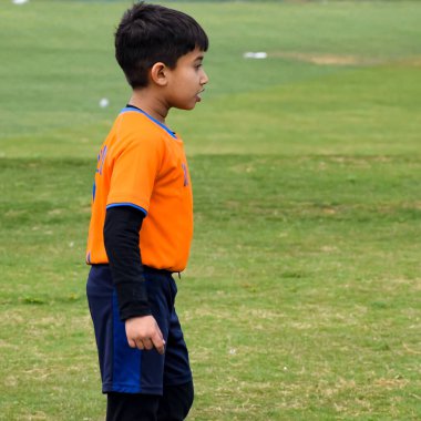 Yeni Delhi, Hindistan - 26 Ocak 2020: Kötü bir futbol sahasında bölgesel Derby şampiyonasında yerel futbol takımının futbolcuları. Stadyumun çimen yeşili sahasında sıcak bir futbol maçı var.