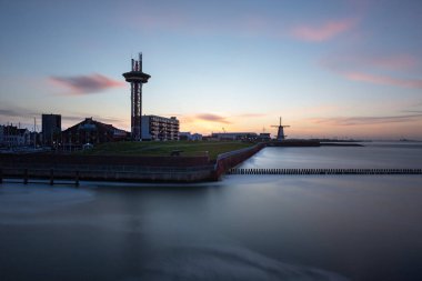 Vlissingen - limanın sabah manzarası. Solda uzun bir gözlem kulesi var, arka planda bir yel değirmeni ve bir liman. Deniz seviyesini uzun süre sakinleştirdi..
