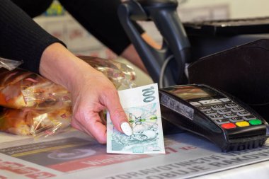 Brno _ Ceska republika _ 06 _ 25 _ 2020 - ödeme terminalinin yanında kadın el yazısı parası. Masanın arkasında haşhaşlı turta yatıyor..