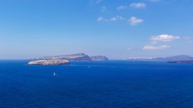 Santorini, Caldera. Güzel mavi deniz manzarası ve Caldera 'nın ortasındaki üç volkanik ada. Arka planda Oia var. Güzel, berrak, mavi gökyüzü.