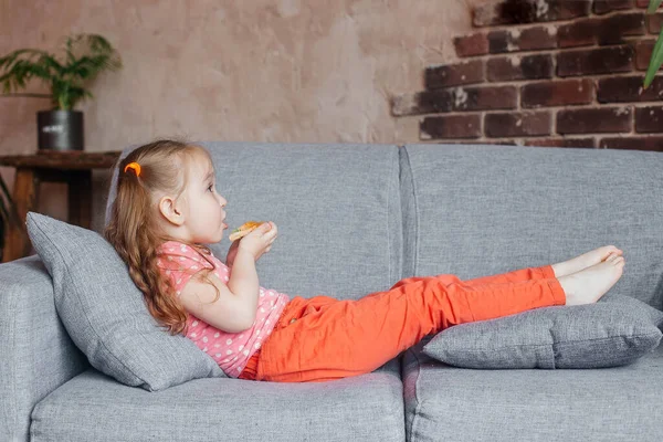 Güzel küçük kız evde pizza yiyor. Fast food konsepti.