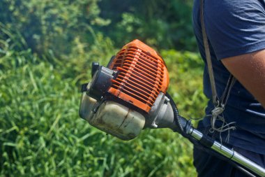 Bahçıvan bir çim biçme makinesiyle çimleri biçer..