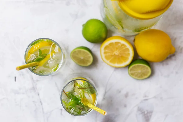 Cold lemonade with ice. Tasty lemonade with lemon, lime and mint. Summer refreshing drink. Top view