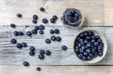 Beyaz ahşap arka planda yaban mersini bardakları. Sağlıklı beslenme kavramı. Antioksidan organik süper yiyecekler. Üst görünüm
