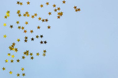 Mavi arka planda küçük altın yıldızlar. Boşluğu kopyala