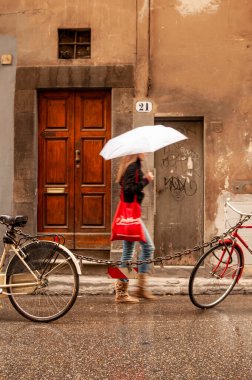 30 Ekim 2012 'de Floransa, Tuscany, İtalya' da şemsiyeli ve bisikletli insanlar.