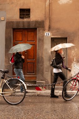 30 Ekim 2012 'de Floransa, Tuscany, İtalya' da şemsiyeli ve bisikletli insanlar.