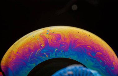 Yüzeyde renkli yansımaları olan sabun köpükleri