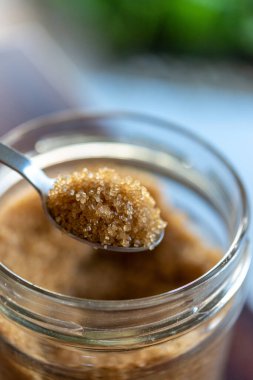 Cam şeker kasesinde bir kaşık esmer organik şeker.