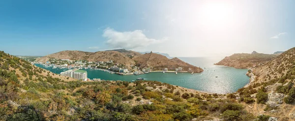 Scenic panoramic view of Balaclava bay with yachts from the ruines of Genoese fortress Chembalo. Balaklava, Sevastopol, Crimea. Inspirational travel landscape. Aerial photo. Copy space.