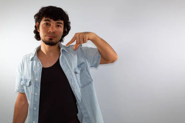 young hispanic deaf man using sign language to communicate, on a white background wearing casual clothes