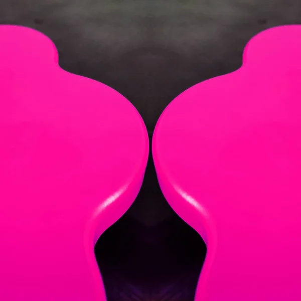 pair mirror image of two vivid bright pink shiny curve shaped tables transformed into e unique unusual shapes patterns and intricate designs
