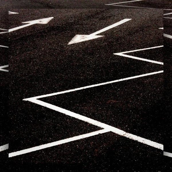 bright white direction arrow and a new black clean asphalt road surface with yellow lane markings