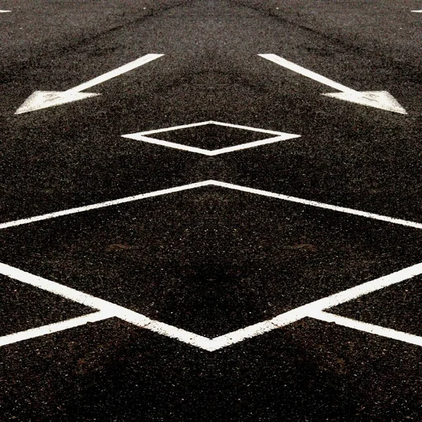 bright white direction arrow and a new black clean asphalt road surface with yellow lane markings