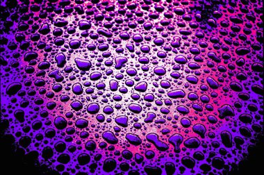 Şiddetli mor ışıkta belirgin yağmur damlalarının fotoğrafı