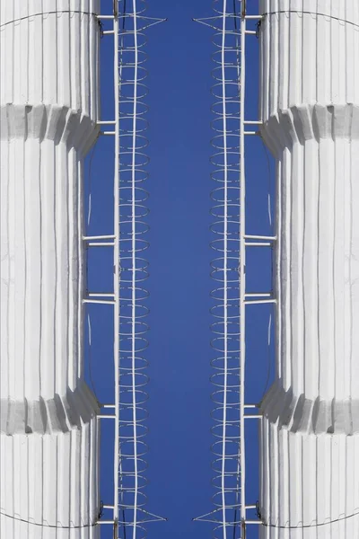 Biały Komin Przemysłowy Bocznymi Drabinami Dostępowymi Bezchmurne Niebieskie Niebo Geometrycznymi — Zdjęcie stockowe