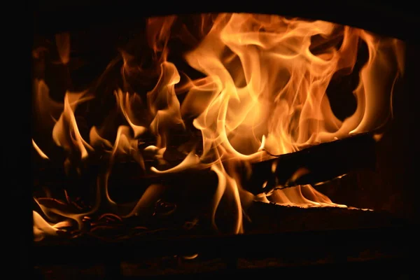 Toros de madeira queimando na lareira com as línguas de chama — Fotografia de Stock