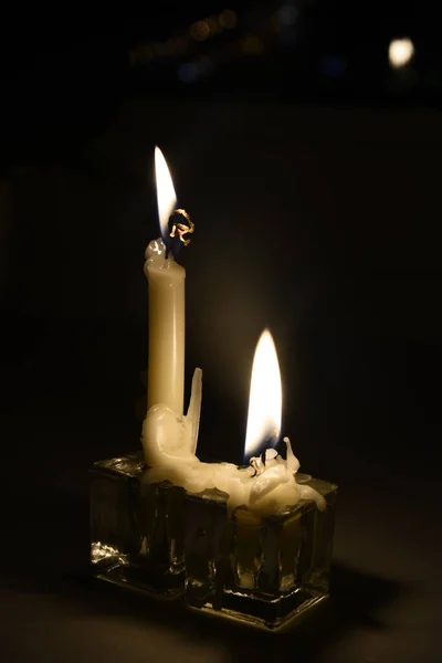 Twee brandende kaarsen gloeiend in de duisternis creëren romantische sfeer — Stockfoto