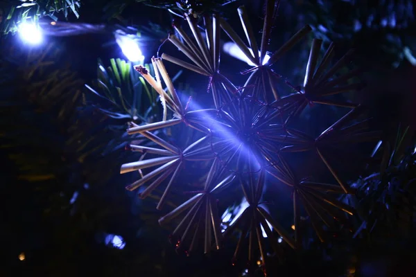Decoración del árbol de Navidad juguetes ecológicos, copo de nieve hecho de paja y bombillas brillantes — Foto de Stock