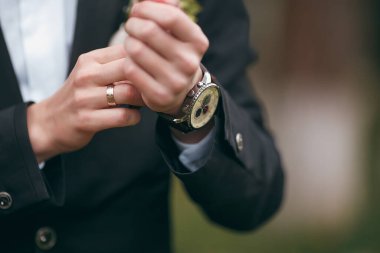Resmi kıyafetlerini giyerken kol düğmelerini takan bir damat. Kol düğmelerini düzelten bir adam. Damat kıyafeti