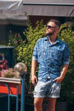 Bahar parkında yürüyen genç adam. Güneşli bir gün. Vesna. Komik adam. İyi bir ruh hali..