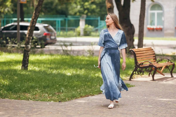 Stilvolles Mädchen posiert in einem Kleid in einem sonnigen Frühlingspark. Fröhliches, glückliches Porträt eines schönen Mädchens im Sommer — Stockfoto