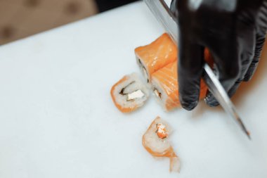 Japon şef beyaz tahtada suşi yapıyor.