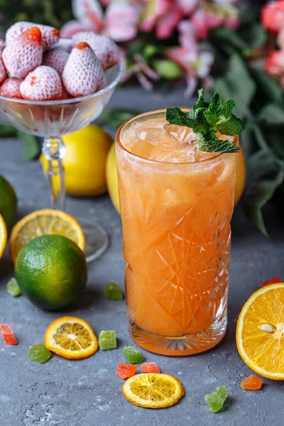 夏の新鮮な冷たい飲み物 テーブルの屋外にミントとジャグとレモンとオレンジで氷のレモネード ガラスのオレンジレモネード — ストック写真
