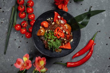 Biftek lokantası. Geleneksel Çin sığır eti kızartması Çin yapımı dökme demir tavada, yemek çubuklarıyla, taş kaplama arka planda. Üst görünüm, alanı kopyala.