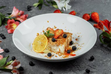 Karamel soslu Napolyon keki. Çilek, yaban mersini ve naneyle süslenmiş muhallebi ve karamel soslu lezzetli börek..